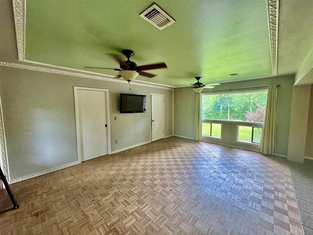 interior space featuring a textured ceiling, light parquet floors, and ceiling fan