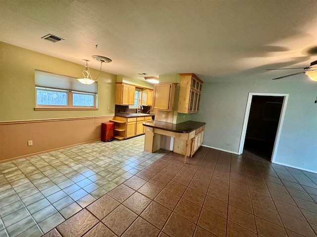 kitchen featuring ceiling fan, light brown cabinets, sink, hanging light fixtures, and light tile patterned flooring