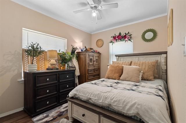 bedroom with wood finished floors, crown molding, baseboards, and multiple windows