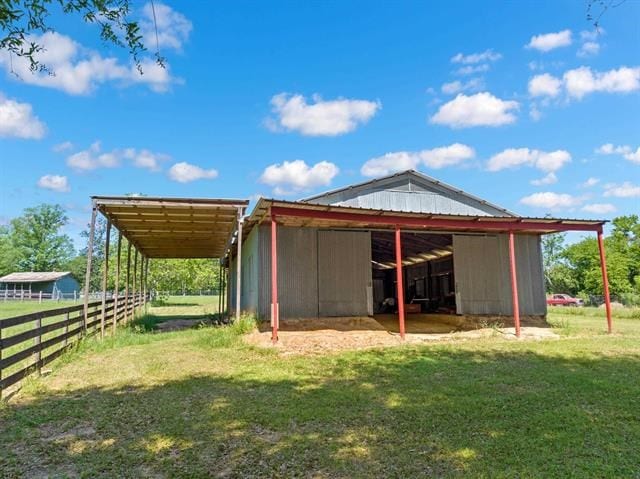 back of house with an exterior structure, an outbuilding, and a carport