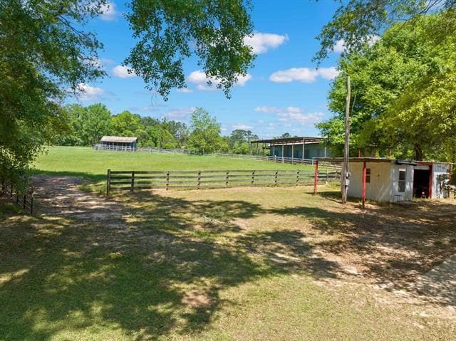 view of yard with a rural view, an outbuilding, and an exterior structure