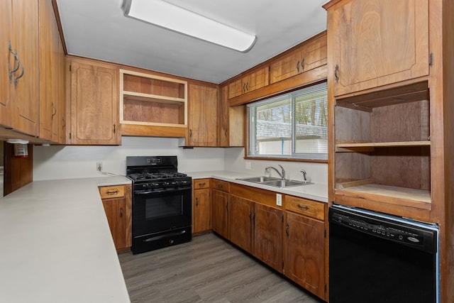 kitchen with black appliances, light hardwood / wood-style floors, and sink