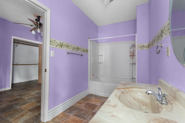 bathroom with vanity, ceiling fan, and tiled shower / bath