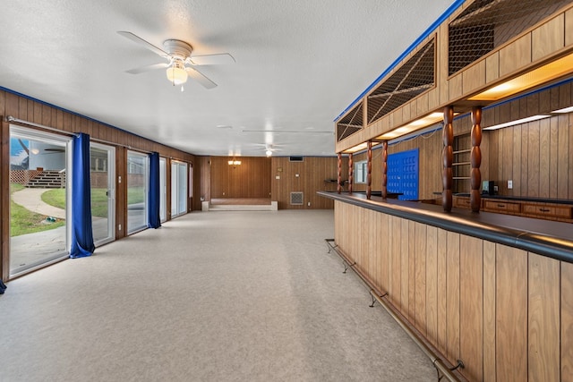 interior space with wood walls, light colored carpet, and a textured ceiling