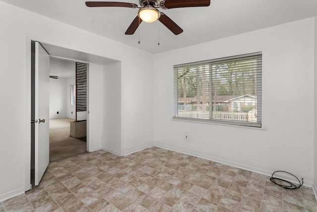 empty room featuring ceiling fan and light colored carpet