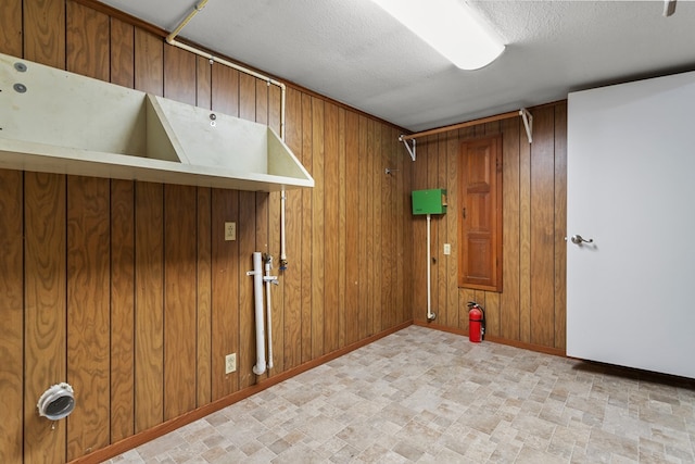 laundry area featuring wooden walls