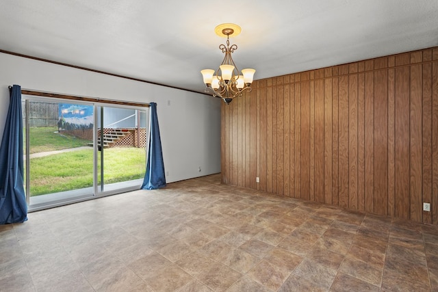 empty room featuring wooden walls and a notable chandelier