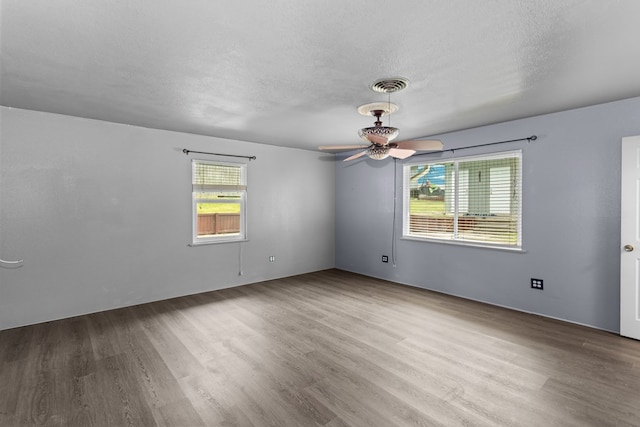 unfurnished room with wood-type flooring, a textured ceiling, and ceiling fan