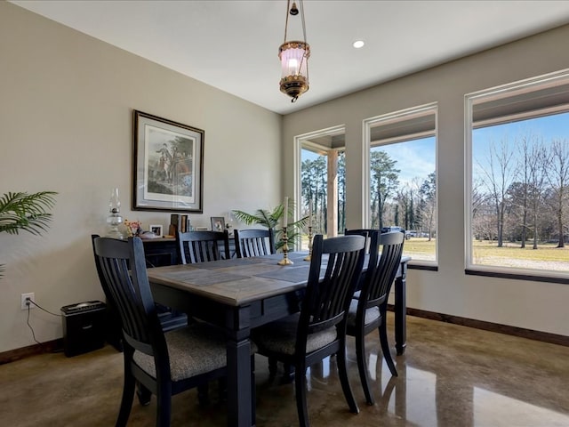 dining space with finished concrete flooring, baseboards, and a healthy amount of sunlight