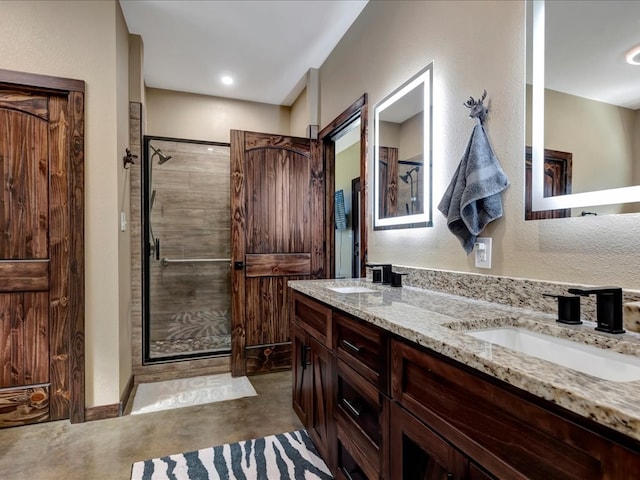 bathroom featuring concrete flooring, a stall shower, a sink, and double vanity