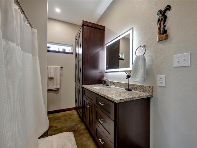 full bathroom with vanity and baseboards