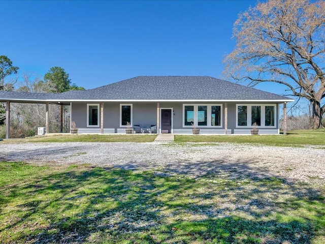 view of front of house featuring covered porch, a shingled roof, and a front lawn