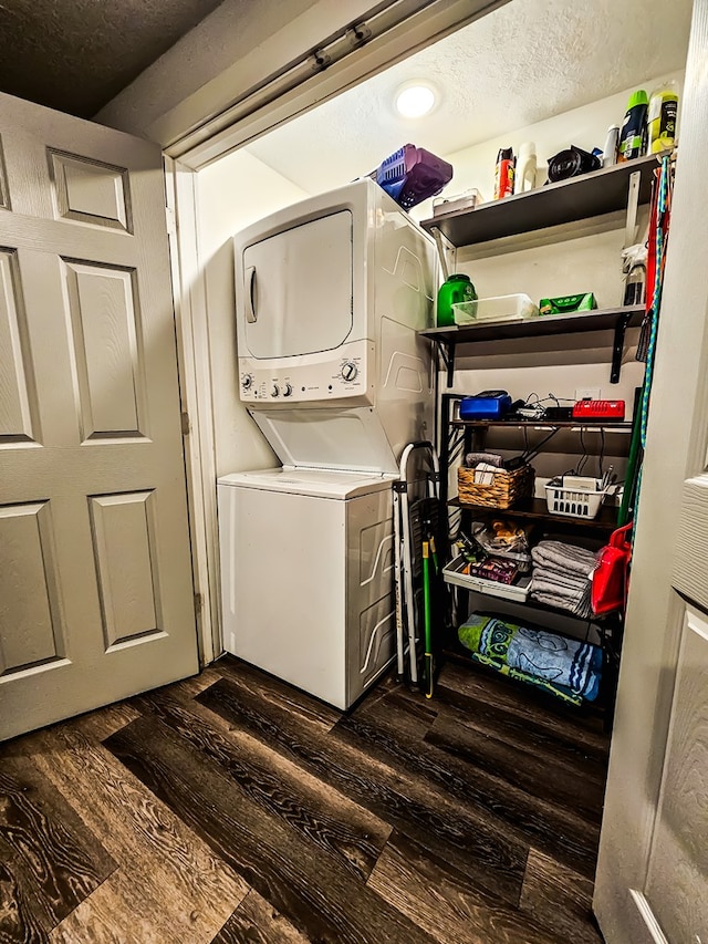 laundry area featuring a textured ceiling, dark hardwood / wood-style flooring, and stacked washer / dryer