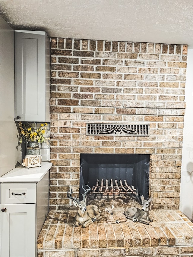 interior details featuring a fireplace, decorative backsplash, and a textured ceiling