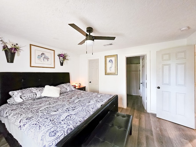 bedroom featuring a textured ceiling, dark hardwood / wood-style flooring, and ceiling fan