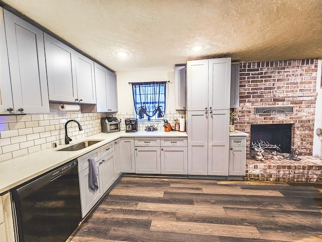 kitchen featuring tasteful backsplash, sink, dark wood-type flooring, and black dishwasher