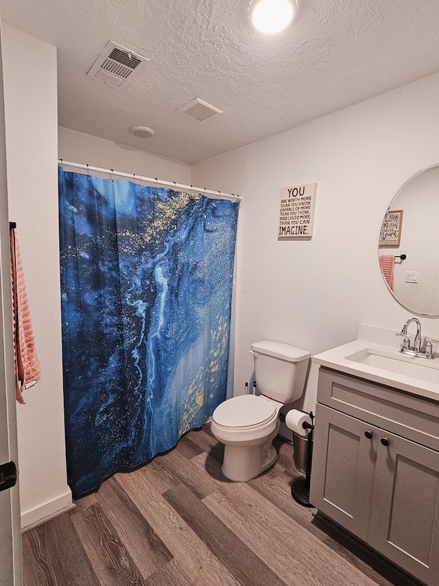 bathroom with vanity, a shower with shower curtain, toilet, a textured ceiling, and wood-type flooring