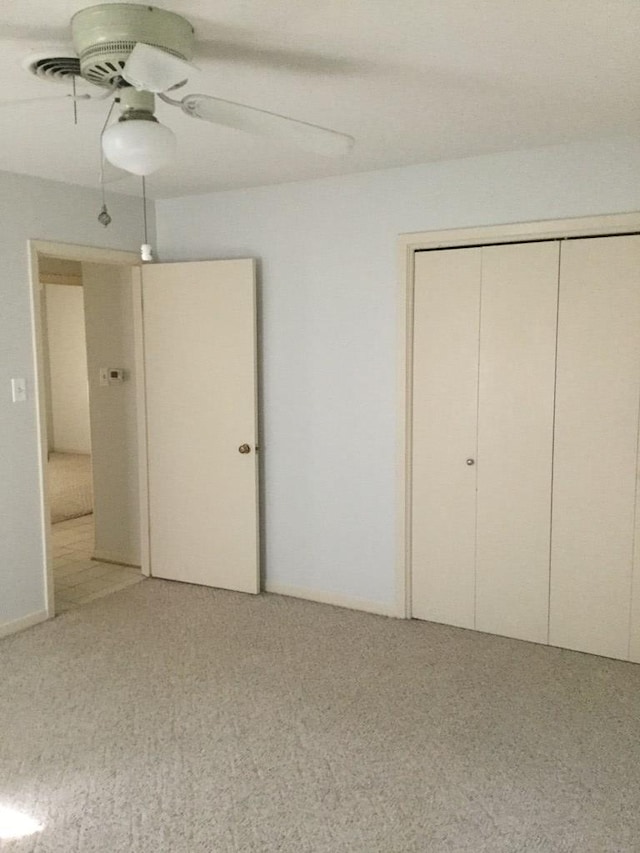 unfurnished bedroom featuring carpet flooring, ceiling fan, and a closet