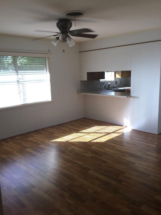 unfurnished living room with dark hardwood / wood-style floors and ceiling fan