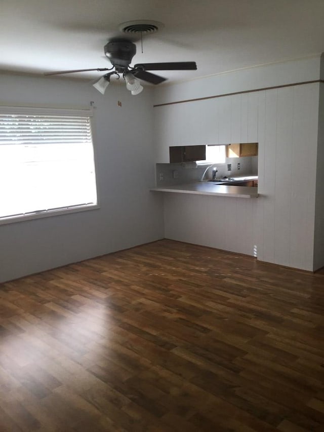 unfurnished living room with ceiling fan, dark hardwood / wood-style floors, and sink