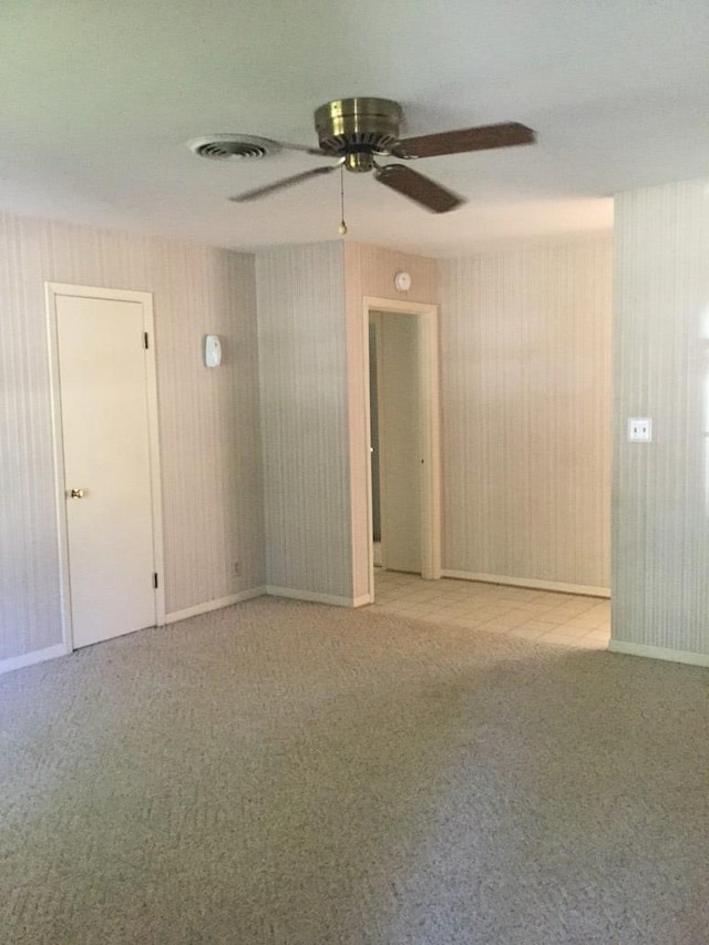 carpeted empty room featuring ceiling fan