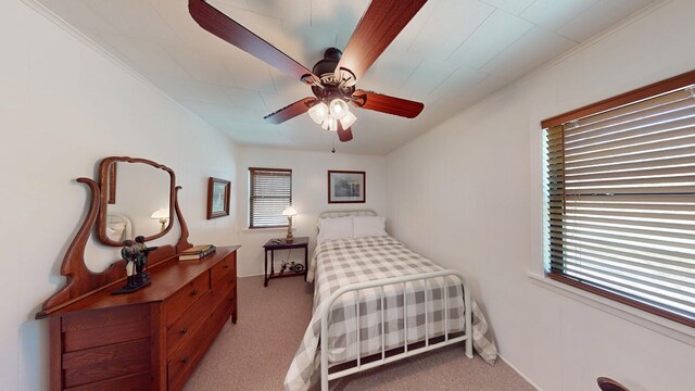 bedroom with light carpet, crown molding, and ceiling fan