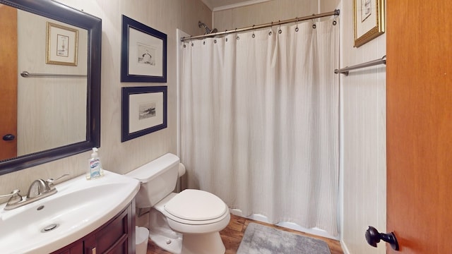 bathroom with toilet, vanity, and curtained shower