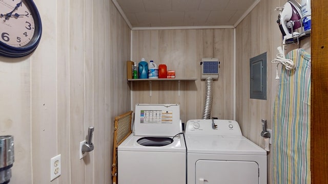 laundry area with crown molding, washing machine and clothes dryer, wooden walls, laundry area, and electric panel