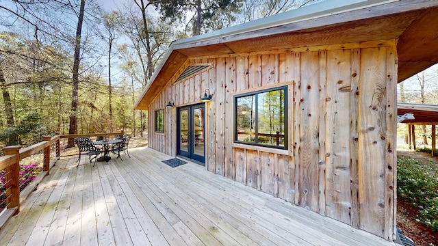 wooden terrace featuring french doors and outdoor dining space
