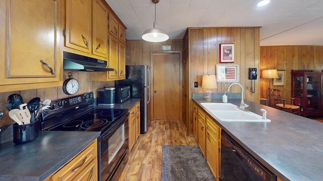 kitchen featuring a sink, under cabinet range hood, black appliances, and brown cabinets