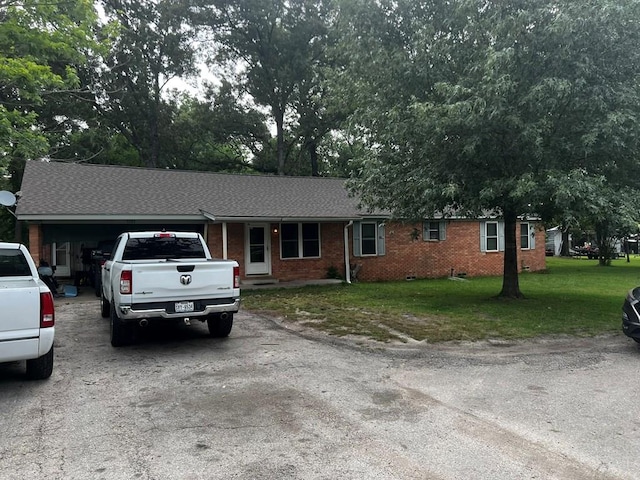 1101 Renfro Dr, Lufkin, TX 75901 - ranch-style house with driveway, a front lawn, an attached garage, brick siding, and a shingled roof