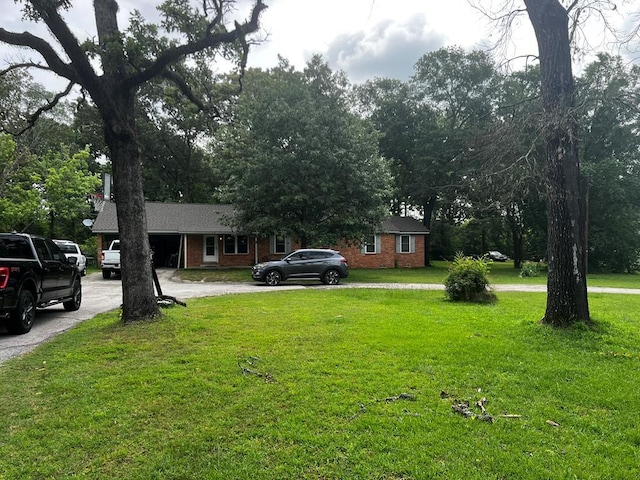 1101 Renfro Dr, Lufkin, TX 75901 - view of front of property with brick siding, curved driveway, and a front lawn