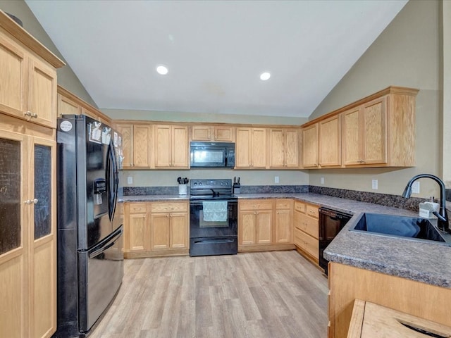 kitchen with dark countertops, black appliances, a sink, and light brown cabinetry