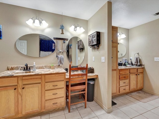 bathroom with visible vents, two vanities, and tile patterned floors