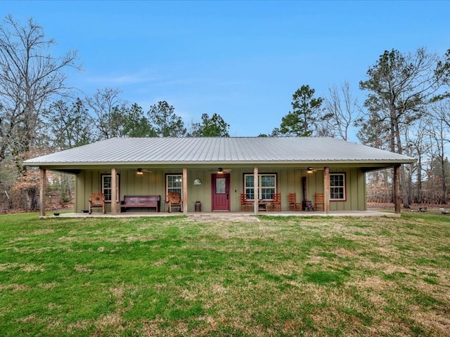 view of front facade featuring board and batten siding, a jacuzzi, a front lawn, and a ceiling fan