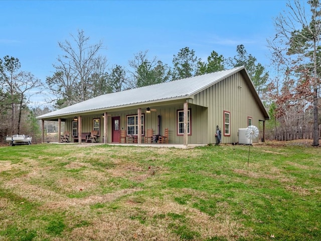view of front of house featuring a porch, a front yard, metal roof, and board and batten siding