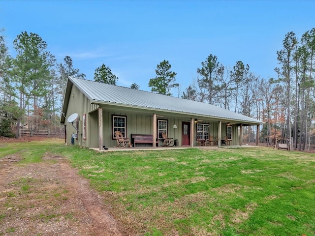 view of front of home with metal roof, a front lawn, and board and batten siding