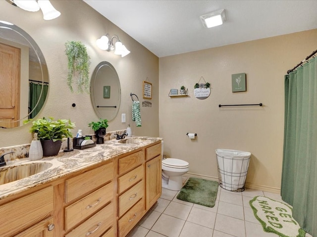 bathroom featuring double vanity, toilet, a sink, and tile patterned floors