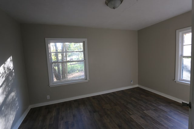 empty room with plenty of natural light and dark hardwood / wood-style floors