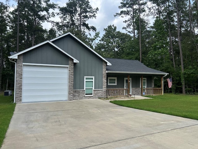 283 Dogwood Rd, Brookeland, TX 75931 - view of front of house featuring a porch, driveway, board and batten siding, an attached garage, and a front yard