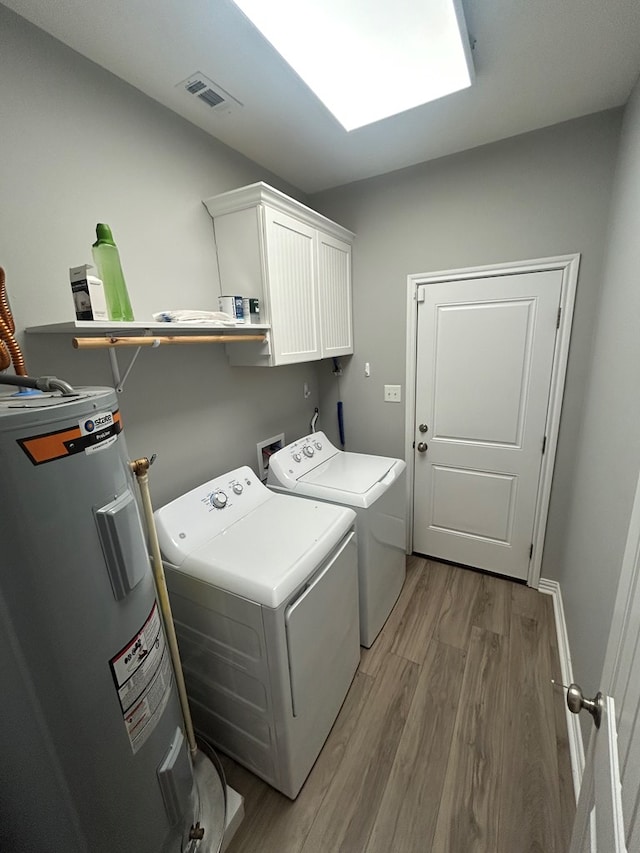 283 Dogwood Rd, Brookeland, TX 75931 - laundry area featuring water heater, washing machine and clothes dryer, light wood finished floors, and cabinet space