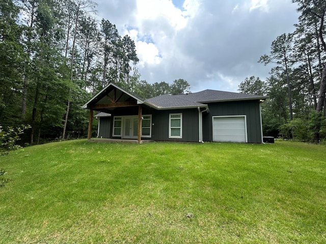 283 Dogwood Rd, Brookeland, TX 75931 - view of front of property featuring a garage, a front yard, french doors, and board and batten siding