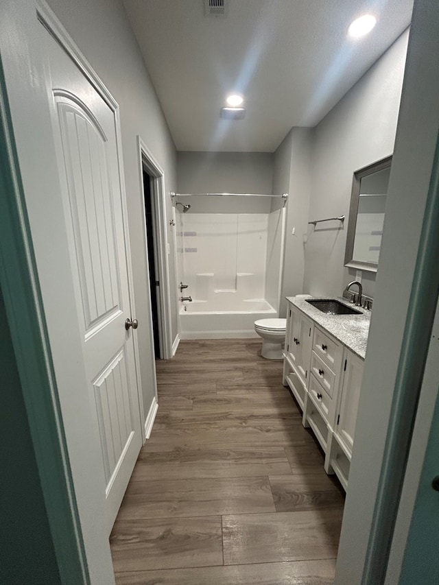283 Dogwood Rd, Brookeland, TX 75931 - full bathroom with washtub / shower combination, toilet, vanity, and wood finished floors