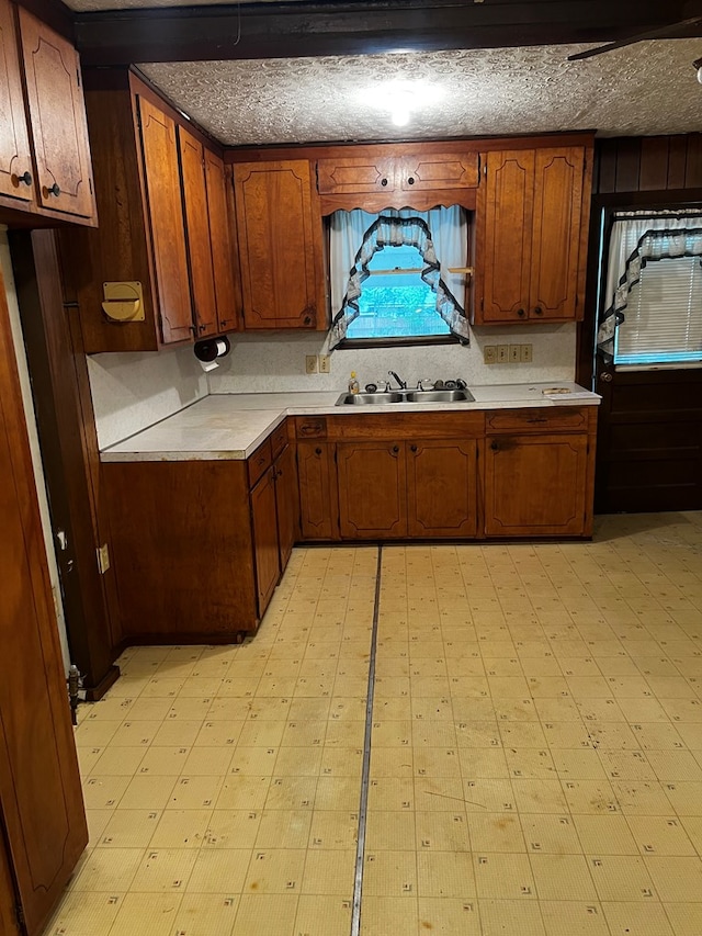 1418N Hendrix St, Diboll, TX 75941 - kitchen with light countertops, a sink, and brown cabinetry