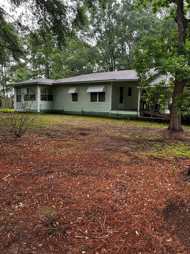 1418N Hendrix St, Diboll, TX 75941 - rear view of house featuring a shingled roof and a sunroom