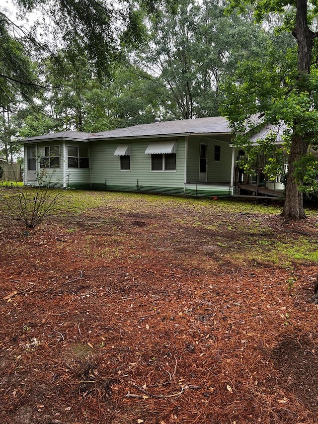 1418N Hendrix St, Diboll, TX 75941 - rear view of property featuring a shingled roof and a sunroom