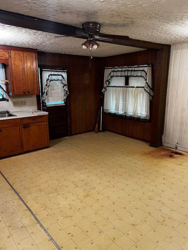 1418N Hendrix St, Diboll, TX 75941 - kitchen featuring ceiling fan, wooden walls, light countertops, light floors, and a sink
