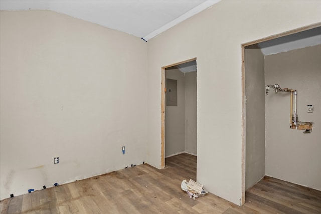 unfurnished bedroom with vaulted ceiling, wood finished floors, and electric panel