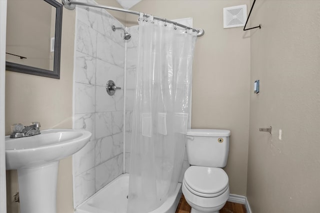full bath featuring visible vents, a sink, a stall shower, and toilet