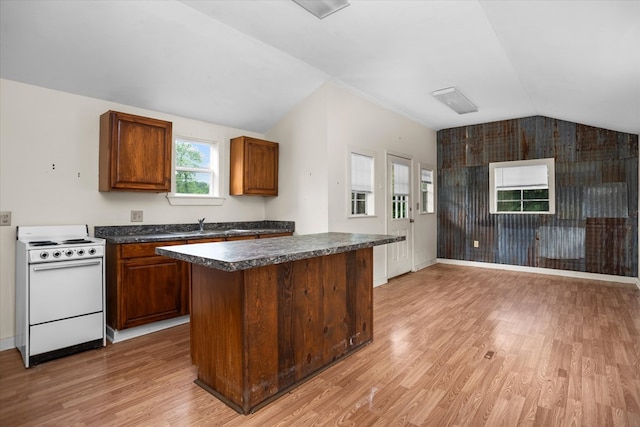 kitchen with dark countertops, light wood-style floors, electric stove, lofted ceiling, and a kitchen island